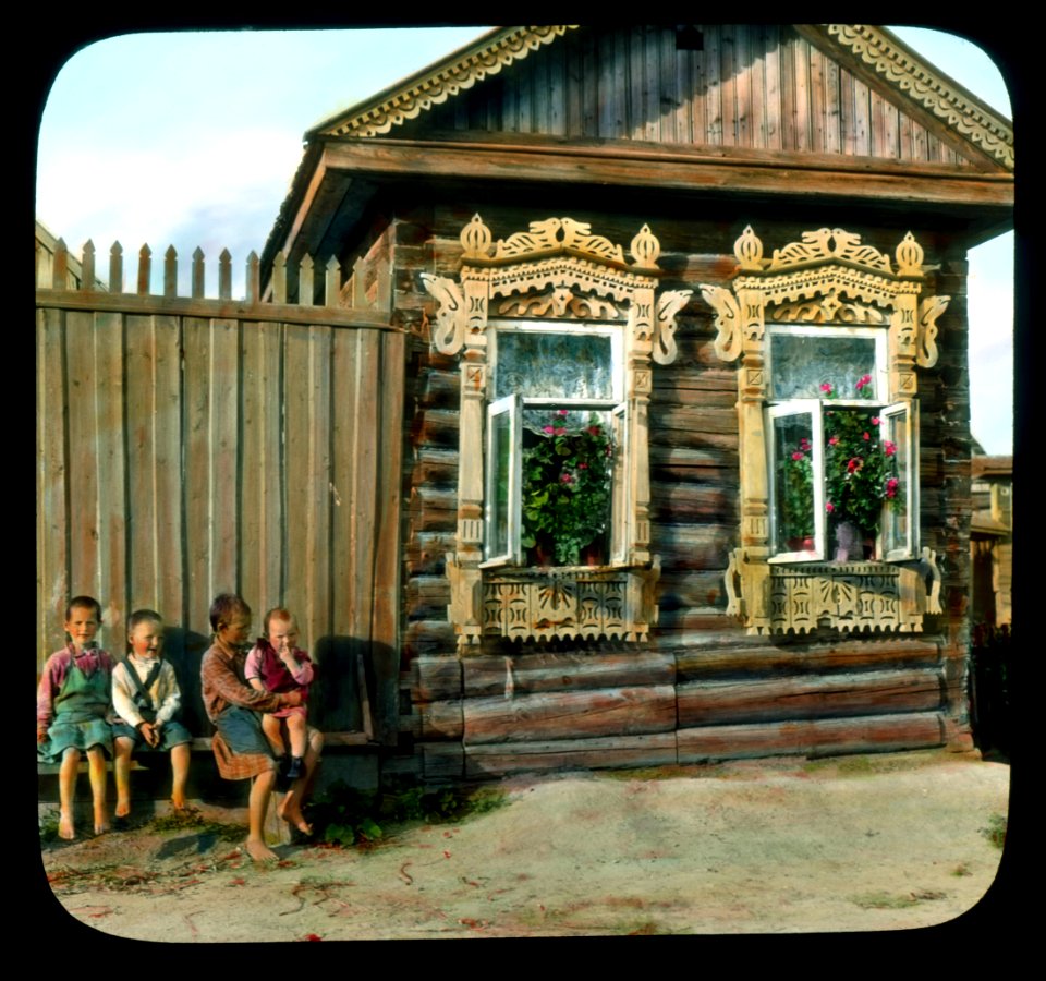 Saint Petersburg children in front of a house with elaborately-carved window frames, near Leningrad
