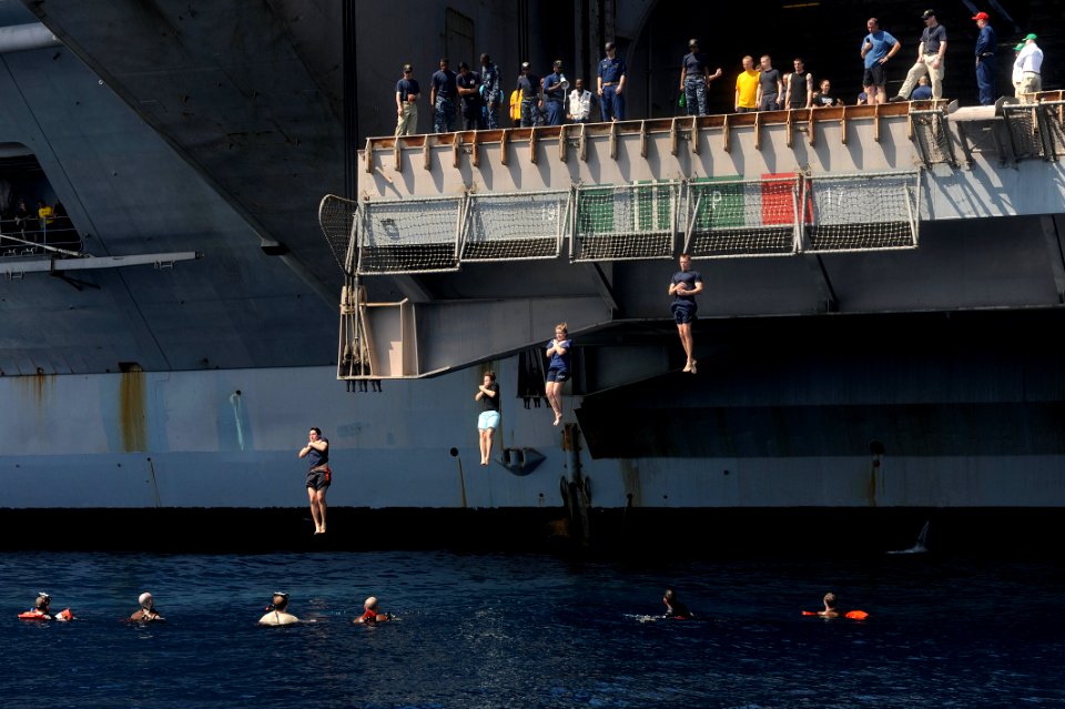 Sailors jump from an aircraft elevator during a swim call. (8736776278)