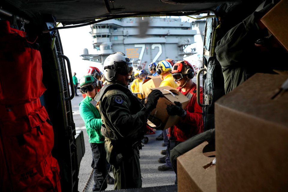 Sailors load boxes of water onto an MH-60R Sea Hawk. (37015526782)