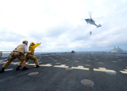 Sailors direct an MH-60 during a vertical replenishment. (8498330470)