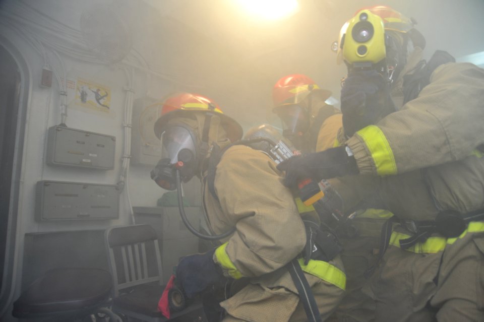 Sailors fight a simulated fire at sea. (8446975929)