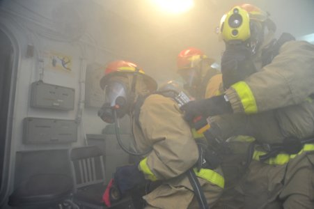 Sailors fight a simulated fire at sea. (8446975929)