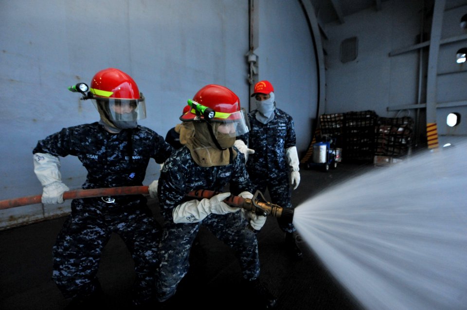 Sailors practice fire hose handling. (8475345595)