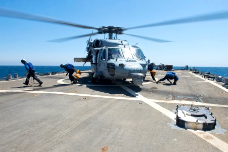 Sailors remove chocks and chains from an MH-60S Seahawk helicopter 140906-N-WD757-183
