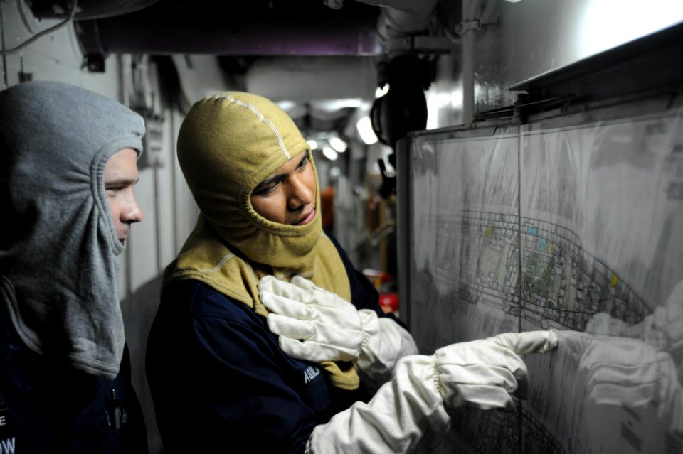 Sailors review a damage control chart. (8243542911)
