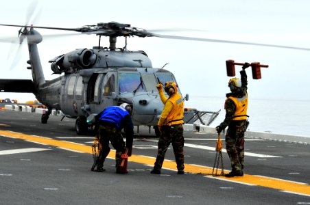 Sailors signal to an MH-60S aboard USS Boxer. (8468328626)