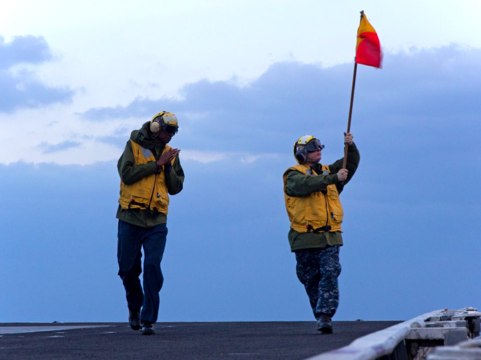 Sailors wave a guide flag. (8199898475)