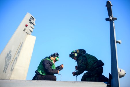 Sailors work on an F-A-18C Hornet at sea. (8414178552)