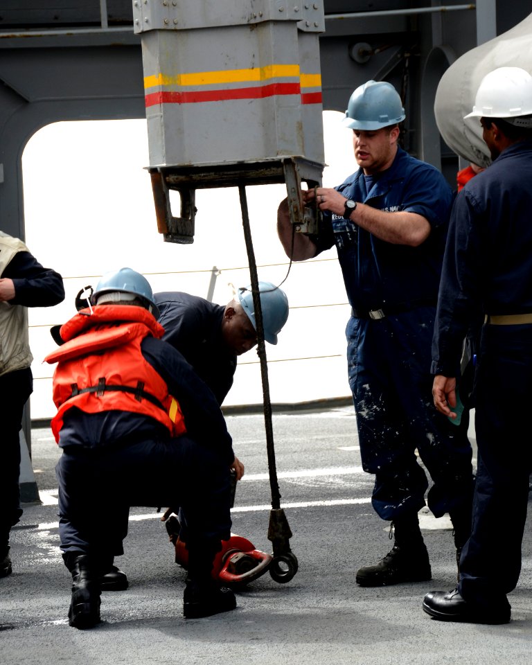 Sailors place an attachment onto a knuckleboom crane 140303-N-HB951-053
