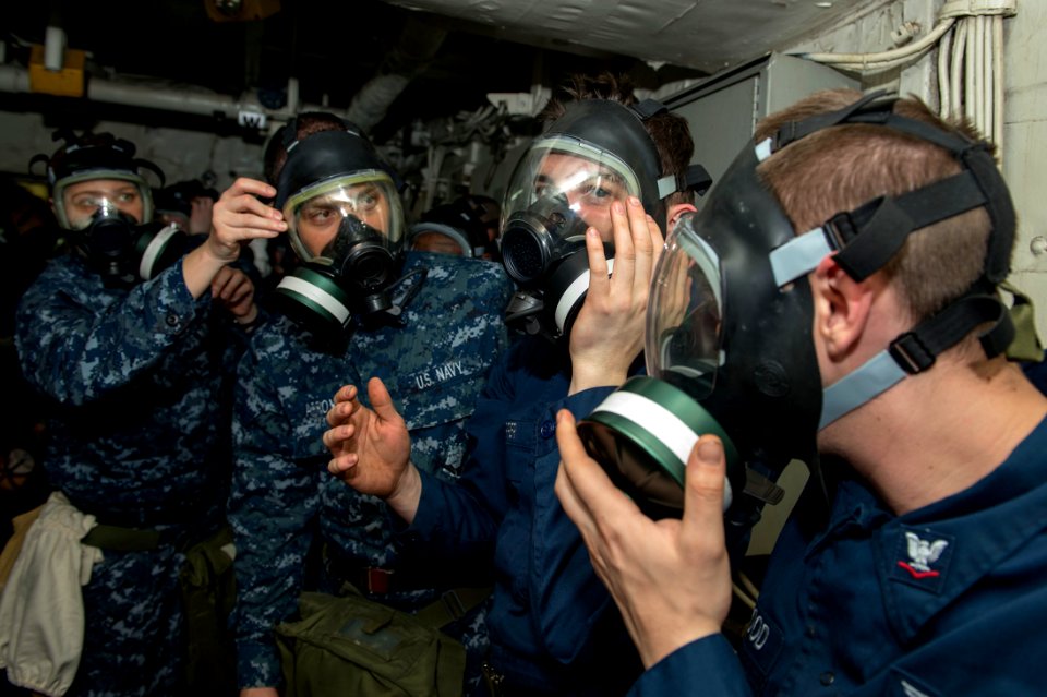 Sailors put on gas masks during a CBR drill. (8576451249)