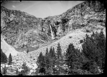 Salt d'aigua de l'ivóde Bagüeñola en un vessant rocós i alguns arbres en primer terme