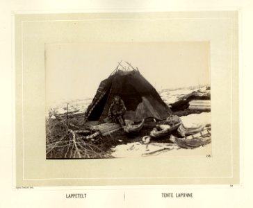 Same i pesk ved teltet som er slått opp på den snødekte vidda. Han sitter på bunnen av en pulk - Norsk folkemuseum - NF.15006-053