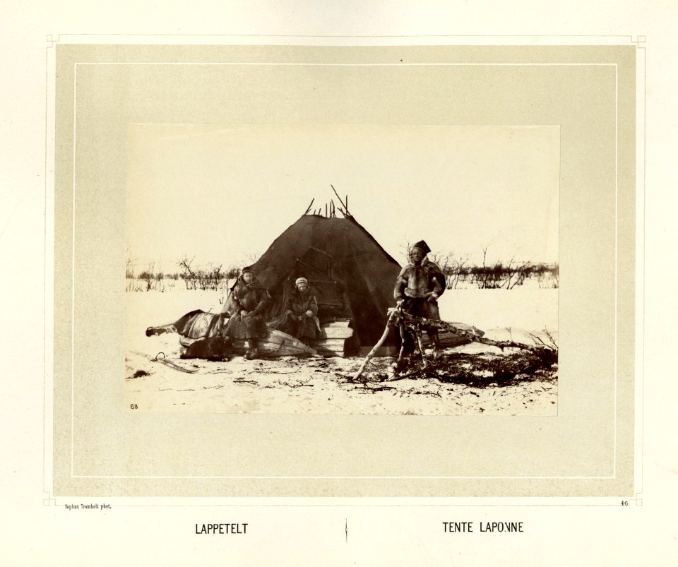 Samer i pesk foran teltet sitt. Det ligger to sleder eller pulker ved inngangen - Norsk folkemuseum - NF.15006-047