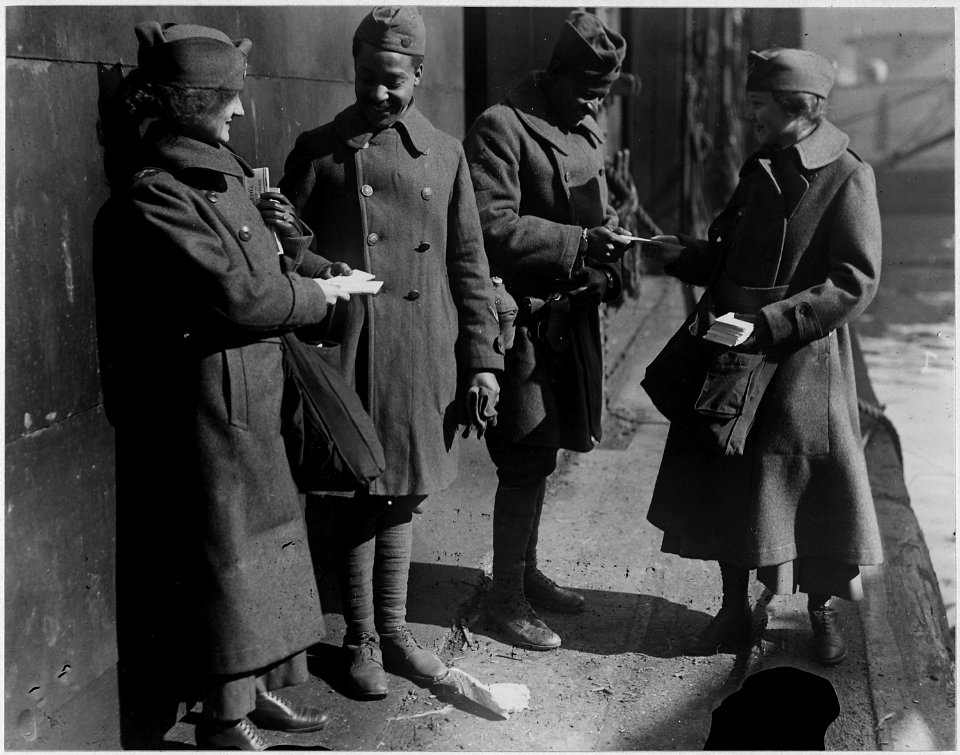 Salvation Army lassies giving sweets to returned (African American) soldiers. Two soldiers of the 3 . . . - NARA - 533625