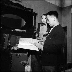 San Francisco, California. Dave Tatsuno re-reads notes he compileed while he was a student at the U . . . - NARA - 536039 photo