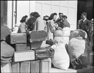 San Francisco, California. With baggage stacked, young residents of Japanese ancestry await a bus a . . . - NARA - 536064