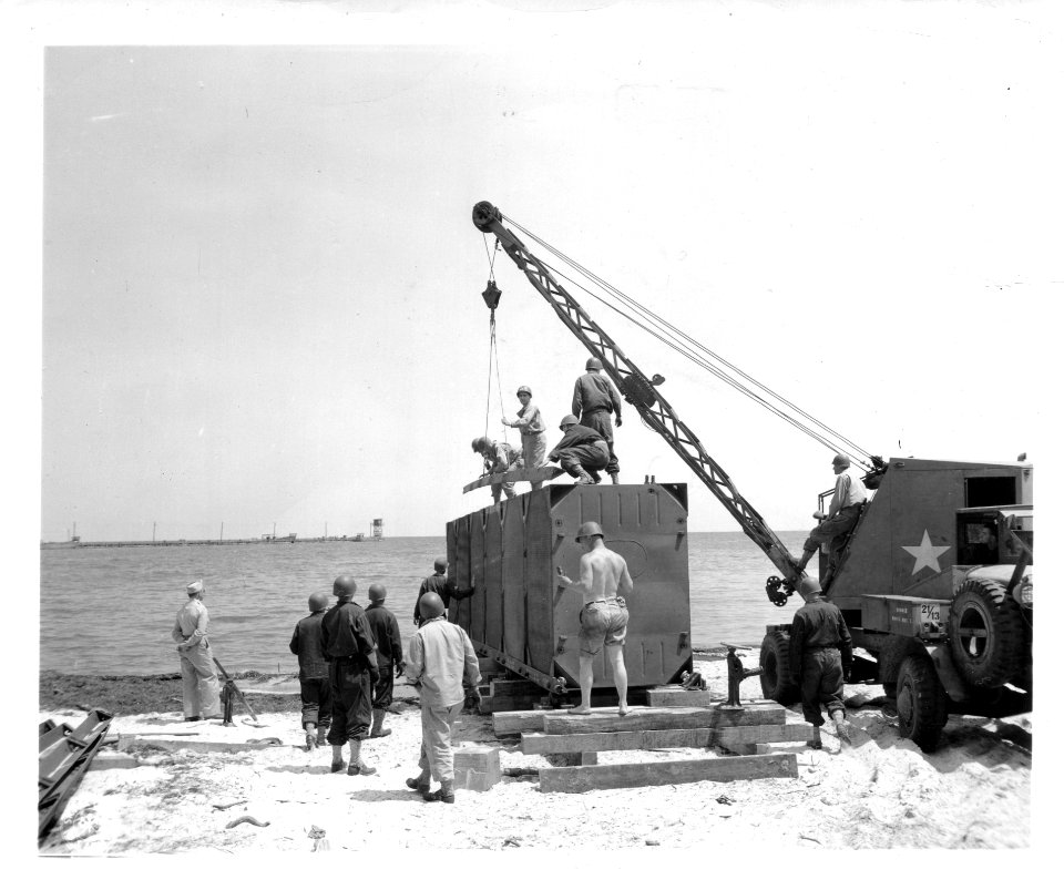SC 190486 - Men of an Engineer Port Construction and Repair Group at ASFTC Camp Gordon Johnston, Fla., build a floating dock from Navy pontoon gear. 9 May, 1944