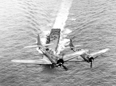 SBDs fly over USS Enterprise (CV-6) in November 1943