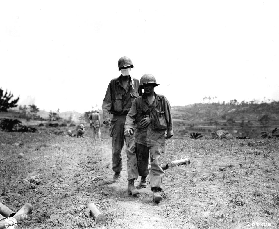 SC 207308 - Two wounded men make their way to a medical aid station on Okinawa