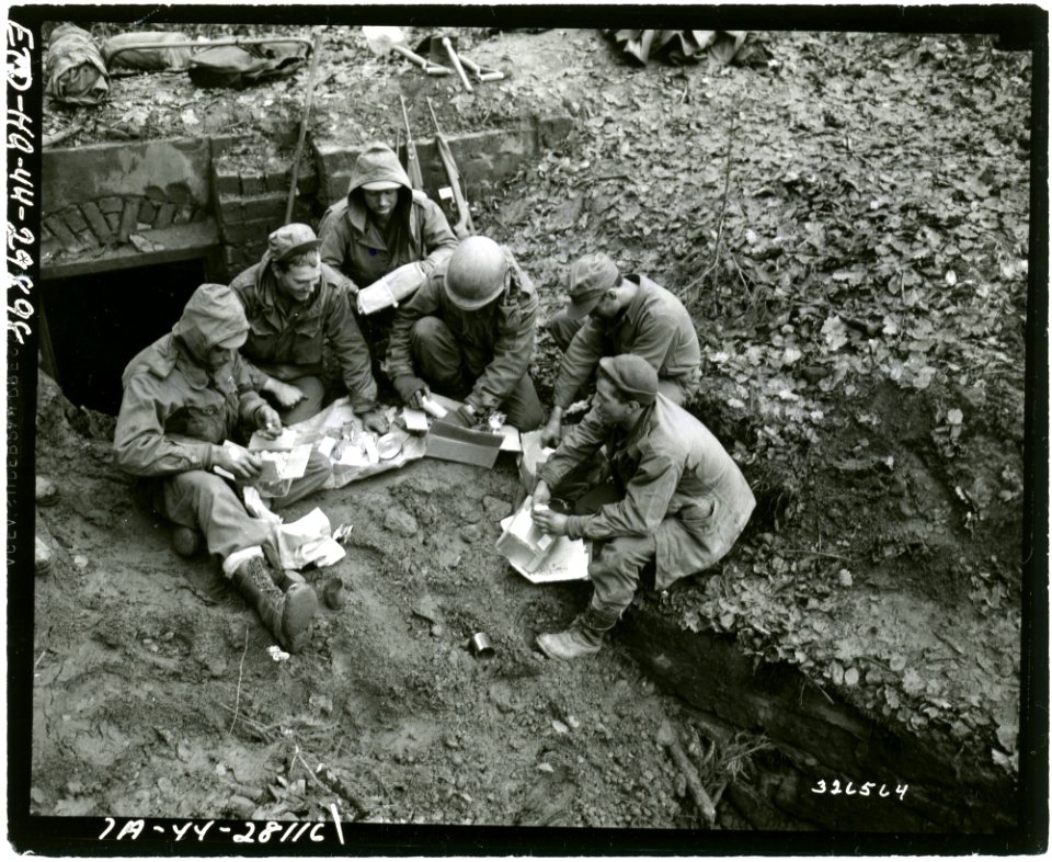 SC 326564 - Infantrymen of Company C, 2nd Bn., 389th Regt., 100th Div., open Christmas boxes while they are waiting for orders to attack the Maginot line. Bitche area, France