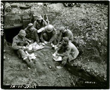 SC 326564 - Infantrymen of Company C, 2nd Bn., 389th Regt., 100th Div., open Christmas boxes while they are waiting for orders to attack the Maginot line. Bitche area, France