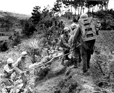 SC 207309 - Army medics work hard to get this litter case over the difficult terrain on Okinawa to an aid station