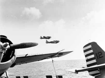 SBD Dauntless of VS-5 fly past USS Yorktown (CV-5) in April 1942
