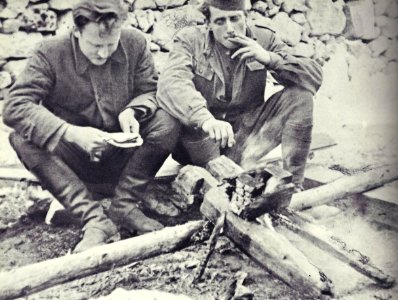 Saniteteni referent 14. divizije Stane Pirc in njegov pomočnik Albin Polk Fajfa ob ognju v taboru 14. divizije na Starih ogencah nad Leskovo dolinu v začetku novembra 1943