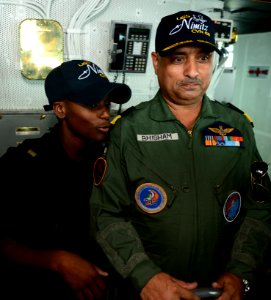 Seaman Emani Lovett teaches Indian Coast Guard DIG Bhisham Sharma how to man the helm aboard the aircraft carrier USS Nimitz (CVN 68) in the Bay of Bengal during Exercise Malabar 2017