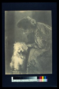 Seated woman petting her white dog LCCN2004676285 photo