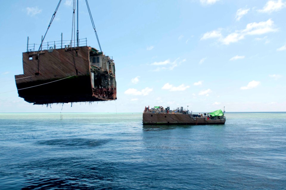 A crane vessel removes a hull section of the former USS Guardian. (8594721557)