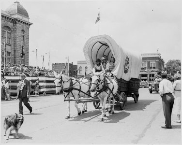 A covered wagon drawn by two white mules passes in front of the reviewing platform (in the distance) on which... - NARA - 199908