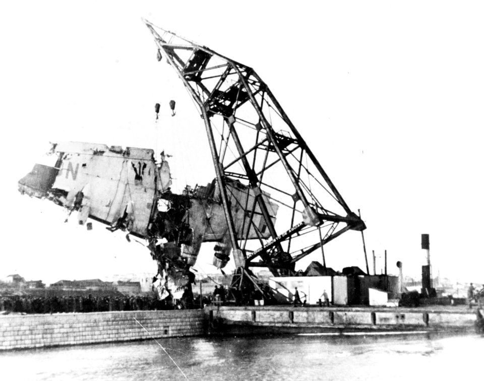 A floating crane places the wreckage of PAA Boeing 314 Yankee Clipper on a quai at Lisbon, Portugal, 22 February 1943 (NH 43451)
