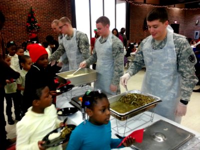 Army and Air Force members from the Joint Base Anacostia-Bolling (JBAB) serve food to youth 131218-N-CG900-007 photo