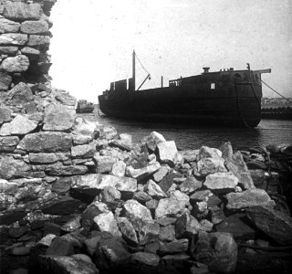 C45f462. Barco anclado vista através de un muro derrumbado