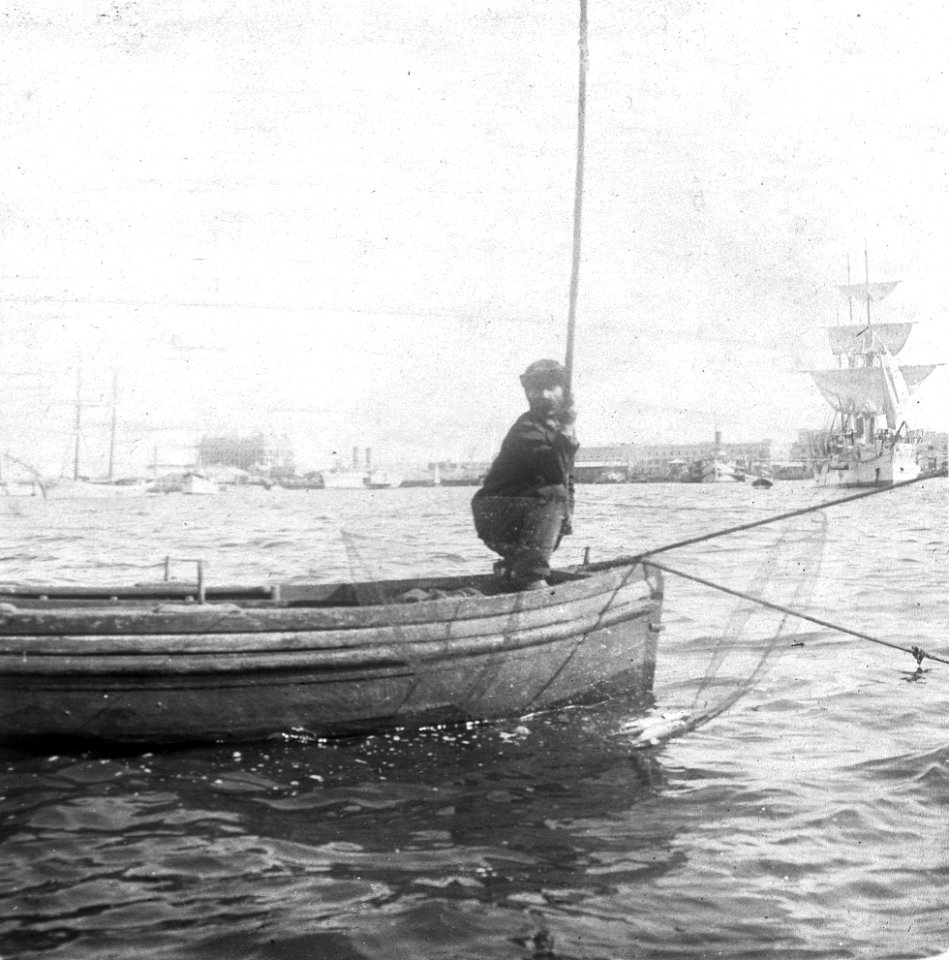 C47f506. Pescador cña en mano en un bote
