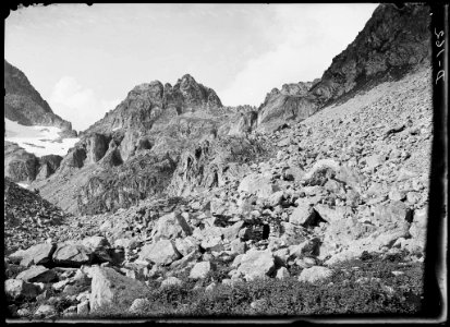 Cabanya de pedra en un vessant rocós i una glacera a l'esquerra