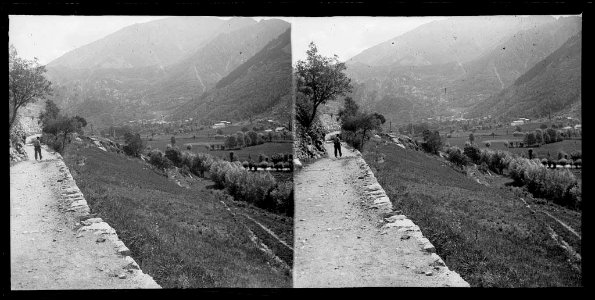 Carretera amb un home en una vall ampla amb Andorra la Vella al fons