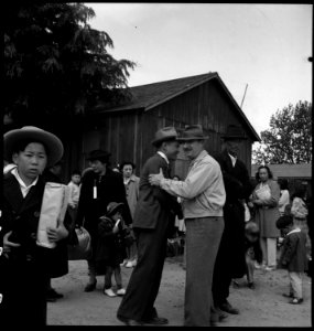 Centerville, California. A friend comes to bid a farmer of Japanese ancestry goodbye while awaiting . . . - NARA - 537559 photo