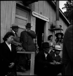 Centerville, California. Evacuees of Japanese ancestry waiting in front of the Japanese American Ci . . . - NARA - 537564 photo