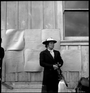 Centerville, California. Awaiting evacuation bus. Posters in Background list of families, buses to . . . - NARA - 537556