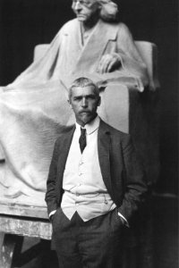Der Bildhauer Adolf Brütt vor dem Entwurf seines Denkmals für Theodor Mommsen, 1908