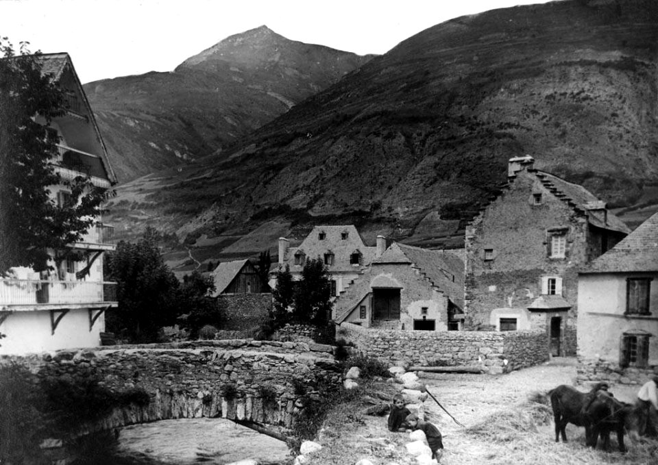 El Pont de Valarties, dins la població d'Arties amb nens i home treballant