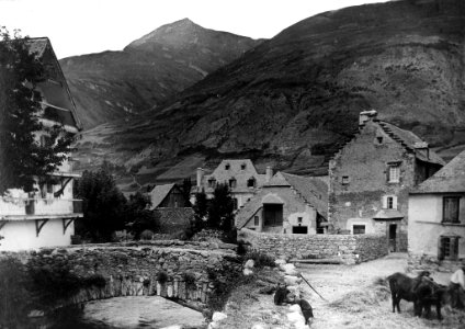 El Pont de Valarties, dins la població d'Arties amb nens i home treballant
