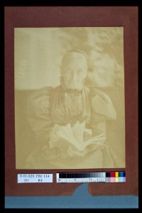 Elderly woman sitting in a chair holding a book, half-length portrait, facing front LCCN2004676297 photo