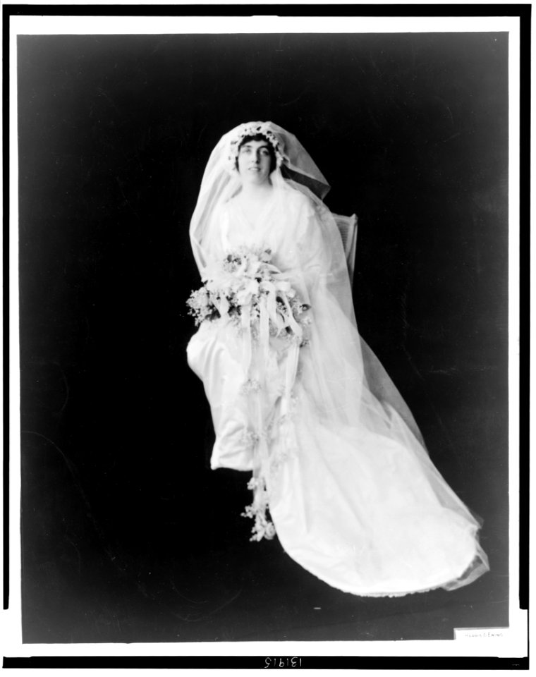 Eleanor Randolph Wilson, full-length portrait, seated, facing front, wearing wedding gown and holding bouquet of flowers) - Harris & Ewing LCCN2002722531