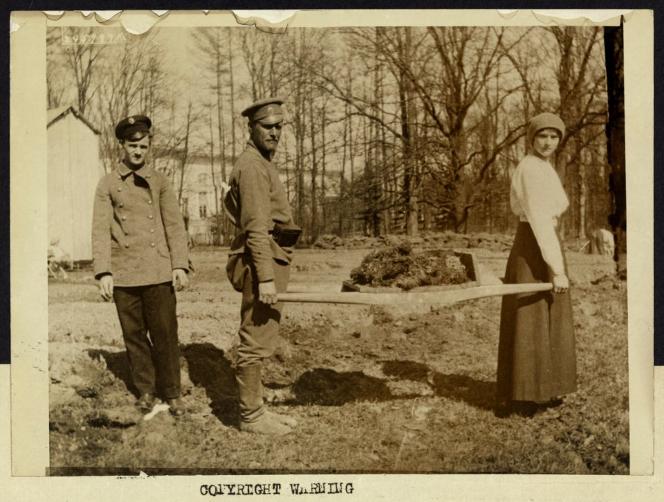 Grand Duchess Tatiana, daughter of the Czar, transporting with the aid of a soldier, lumps of sod on a stretcher. Photo made at Tsarskoe-Selo LCCN2007683266