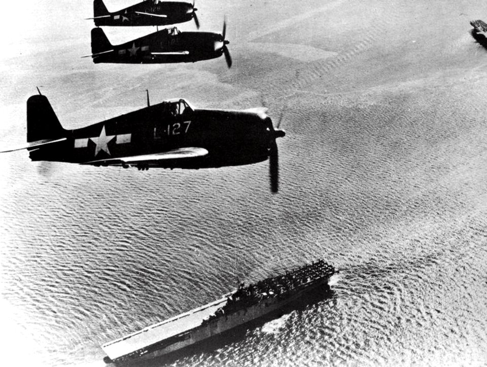 Grumman F6F-5P Hellcats of VF-7A fly over USS Leyte (CV-32), circa in 1947