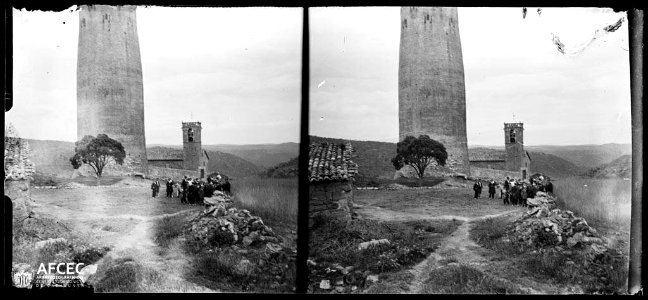 Grup de gent al peu de la torre de Vallferosa i al fons l'església de Santa Maria