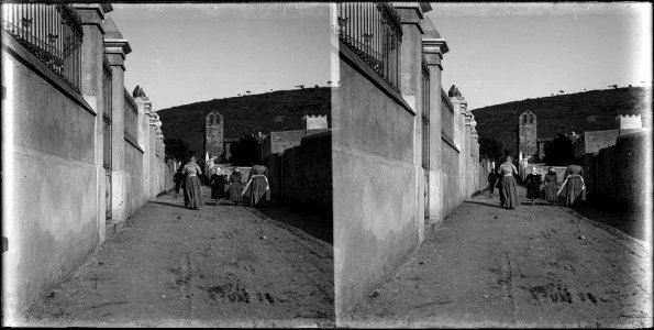 Grup de dones en un carrer i al fons l'església de la Mare de Déu del Coll